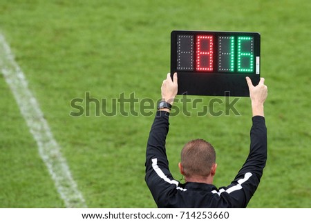The referee shows the number display announcing the change of players during the soccer match