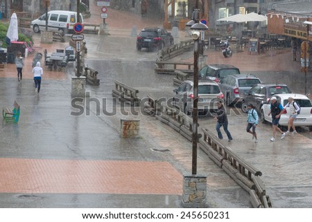 TIGNES, FRANCE - July 13: People run away from the sudden onset of heavy rain July 13, 2013 in Tignes.