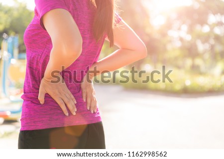 Young asian woman feel pain on her back and hip while exercising, health care concept.