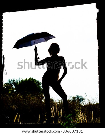 Woman dancing with an umbrella in the ruins of an old house