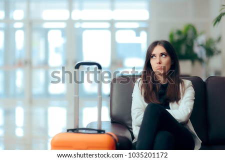 Bored Woman with Suitcase in Airport Waiting Room\
Upset girl traveling along waiting for the next flight