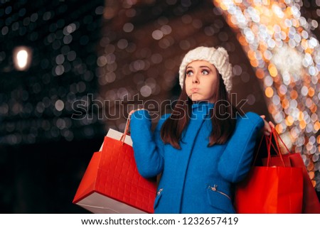 Tired Girl Holding Shopping Bags on Christmas Lights Decor. Exhausted stressed holidays buyer feeling fatigued
