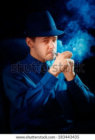 Man with Hat Lighting His Pipe - Man wearing a hat is lighting up a pipe