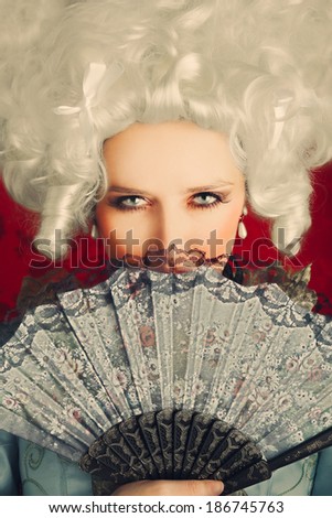 Beautiful Baroque Woman Portrait with Wig and Fan - Baroque style portrait of a young beautiful woman behind a hand fan