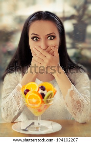 Surprised Young Woman with Fruit Salad Dessert - Beautiful woman looks surprised by a fruit salad dessert