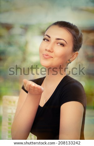 Beautiful Young Woman Blowing Kisses - Colorful portrait of a young woman blowing kisses at the camera