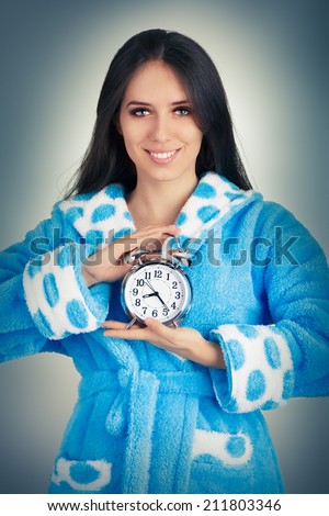 Young Woman in Bathrobe Holding an Alarm Clock - Young woman is holding an analog alarm clock