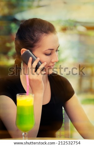 Young Woman with Colorful Cocktail Drink Talking on Her Phone - Beautiful woman talking on her phone while having a cocktail drink on a sunny day