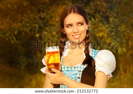 Young Bavarian Woman Holding Beer Tankard - Young woman in German dress holding a glass beer mug