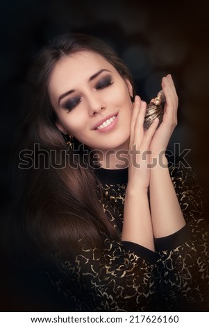 Retro glamour woman holding vintage perfume bottle - Glamorous portrait of a beautiful young woman posing with a vintage perfume bottle