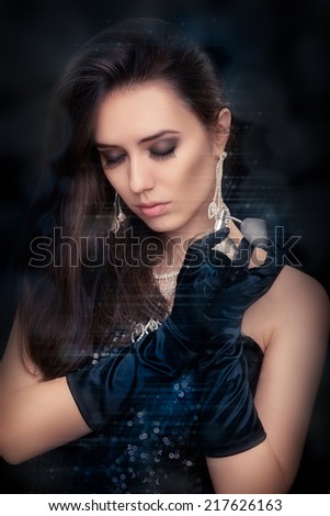 Retro glamour woman holding vintage perfume bottle wearing silver accessories - Glamorous portrait of a beautiful young woman preparing for party using a vintage perfume bottle