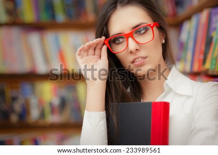 Young Woman Wearing  Glasses and Holding a Book - Portrait of a woman with red eyeglasses holding a book in a library
