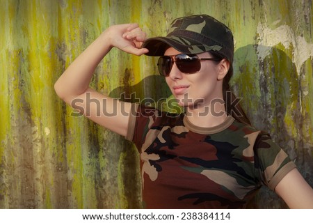 Young Woman Soldier in Camouflage Outfit Saluting - Portrait of a happy beautiful female army soldier