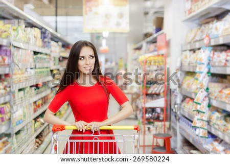Happy Woman Shopping  at The Supermarket - Portrait of a young girl in a market store with a shopping cart