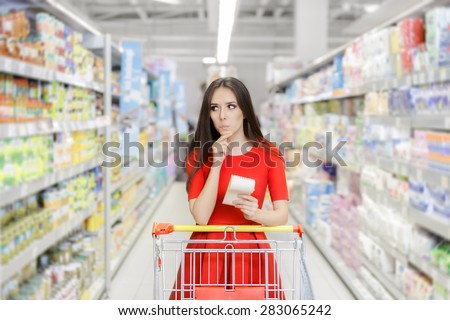 Curious Woman in The Supermarket with Shopping List- Young girl in a market store with a shopping list thinking what to buy