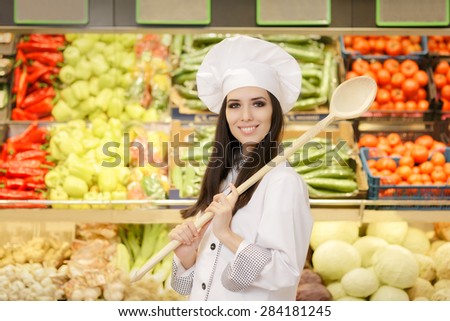 Happy Lady Chef with Big Spoon Shopping for Vegetables - Portrait of a young female cook in a grocery store