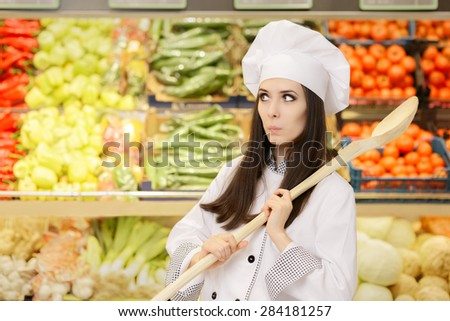 Funny Lady Chef with Big Spoon Shopping for Vegetables - Portrait of a young female cook in a grocery store