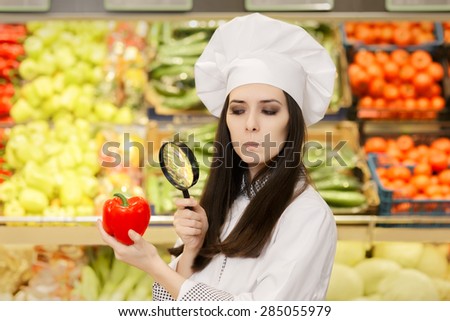 Concerned  Lady Chef Inspecting Vegetables with Magnifying Glass - Portrait of a young female cook in a grocery store checking for best quality ingredients