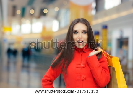 Amazed Girl in a Red Coat Shopping in a Mall - Excited fashion woman with shopping bags in a big mall