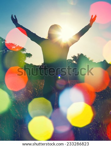 Young girl spreading hands with joy and inspiration facing the sun,sun greeting,freedom ,freedom concept