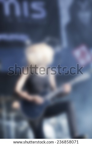 blurred woman  guitar player on concert stage