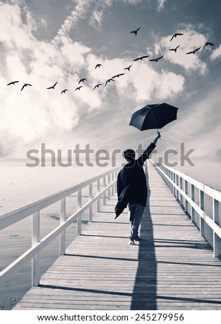 Young man walking on  the pier with umbrella and bird flying above,Happy man,happiness