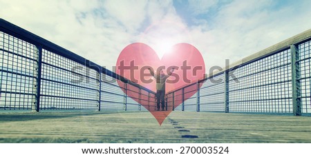 man standing on the edge of pier with hand open wide in the middle of red  heart ,love and freedom concept