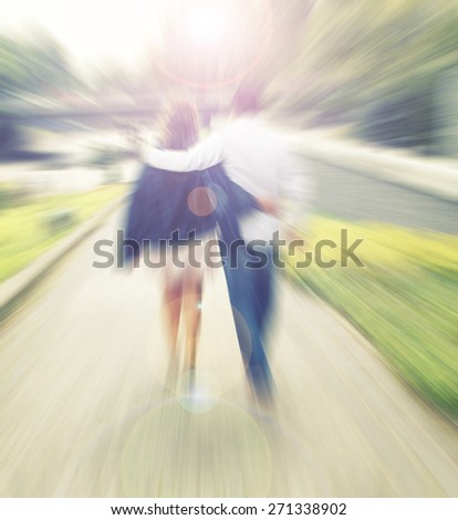 Young happy couple walking in the park, back view,blurry  unfocused background,love and happiness ,couple in love walking