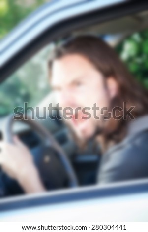 angry driver ,man sitting in the car and screaming at other drivers,blurred background