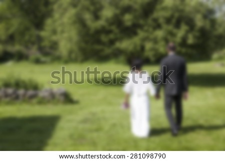 bride and groom walking on green grass,abstract blurred wedding background,love and marriage background