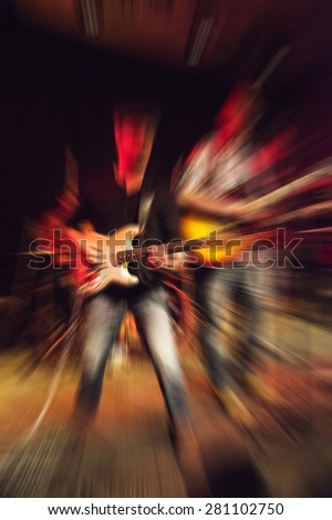 man playing rock guitar on concert, blurred rock background
