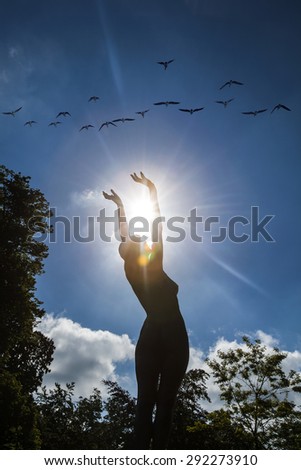 Young woman  with raised hands to the sun \
woman silhouette raising hands to the sun ,freedom and liberty concept