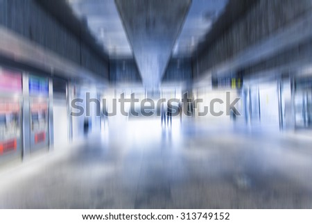 motion blurred people walking in train station in big city