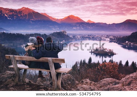 Family travel Slovenia, Europe. Bled Lake one of most amazing tourist attractions. Winter landscape. Top view on Island with Catholic Church in Bled Lake with Castle and Alps Mountains in Background.