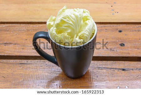 green vegetable lettuce food in single cup on wood table