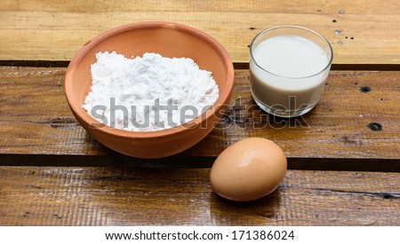 milk and powder with eeg for make bakery on wood table