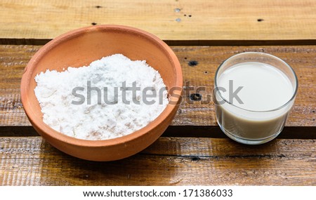 close up powder in bowl and milk  for make bakery on wood table