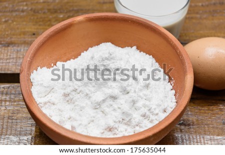 close up powder and milk with eeg for make bakery on wood table
