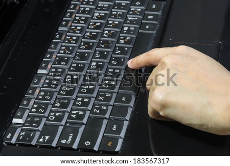 young hand girl press space bar on laptop with thai language