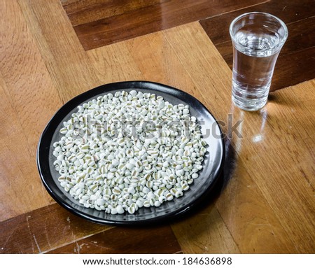 lot of white asia millet on dish with water drink at wood parquet background