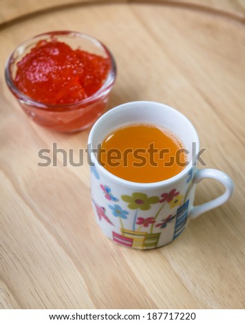 orange water drink and strawberry jam on wood pattern background