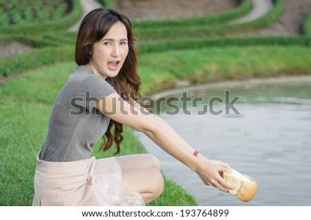 portrait asia Young girl happy and feeding for fish in water lake natural at outdoor garden