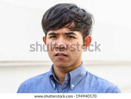 portrait of young asian man wear shirt on old white wall background
