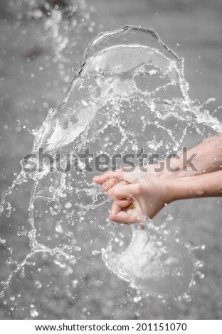 girl hand hold Water balloon explosion and splash water at blur natural background