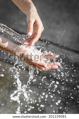 Woman\'s wash hands with water splash at sunrise outdoor background