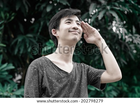 young asia man saluting sign with retro filter at outdoor sunrise natural