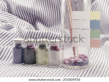 vintage decoration glass bottle, with paper blank label. on fabric background with retro filter