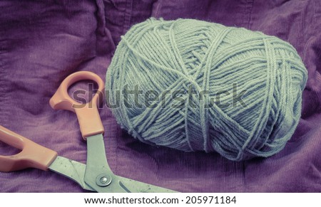 grey Knitting roll and scissors with retro filter on old fabric pattern background