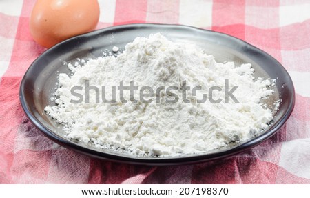 powder and egg for bakery cooking at fabric plaid pattern background