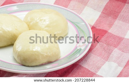 ball of dough for bakery cooking on circle dish at fabric plaid background